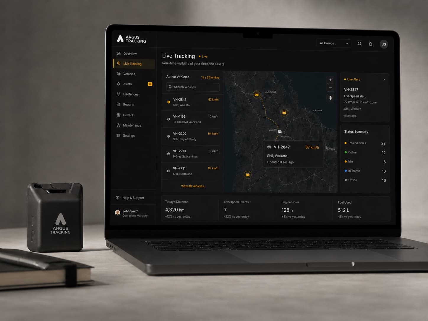 The Argus GPS tracking device beside a laptop showing the live fleet tracking dashboard